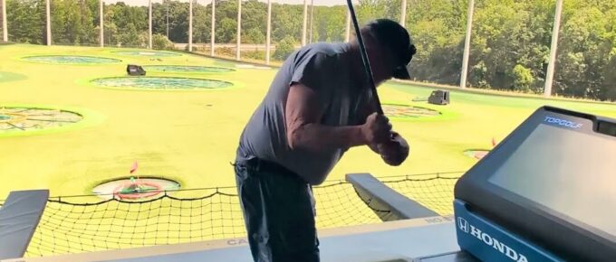 Resident taking a swing at Topgolf with Brookstone Terrace of Greensboro